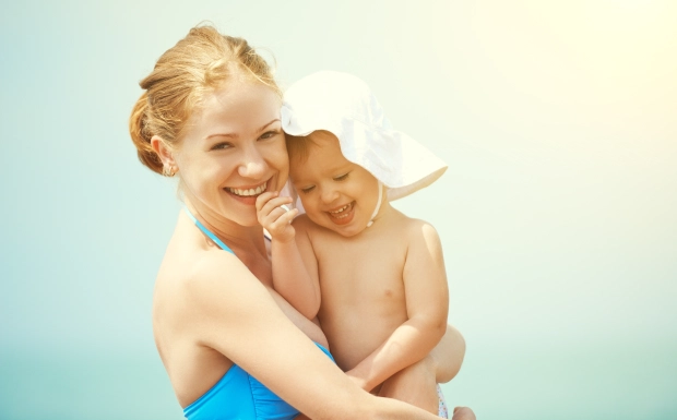 happy family on the beach. mother and baby daughter at sea